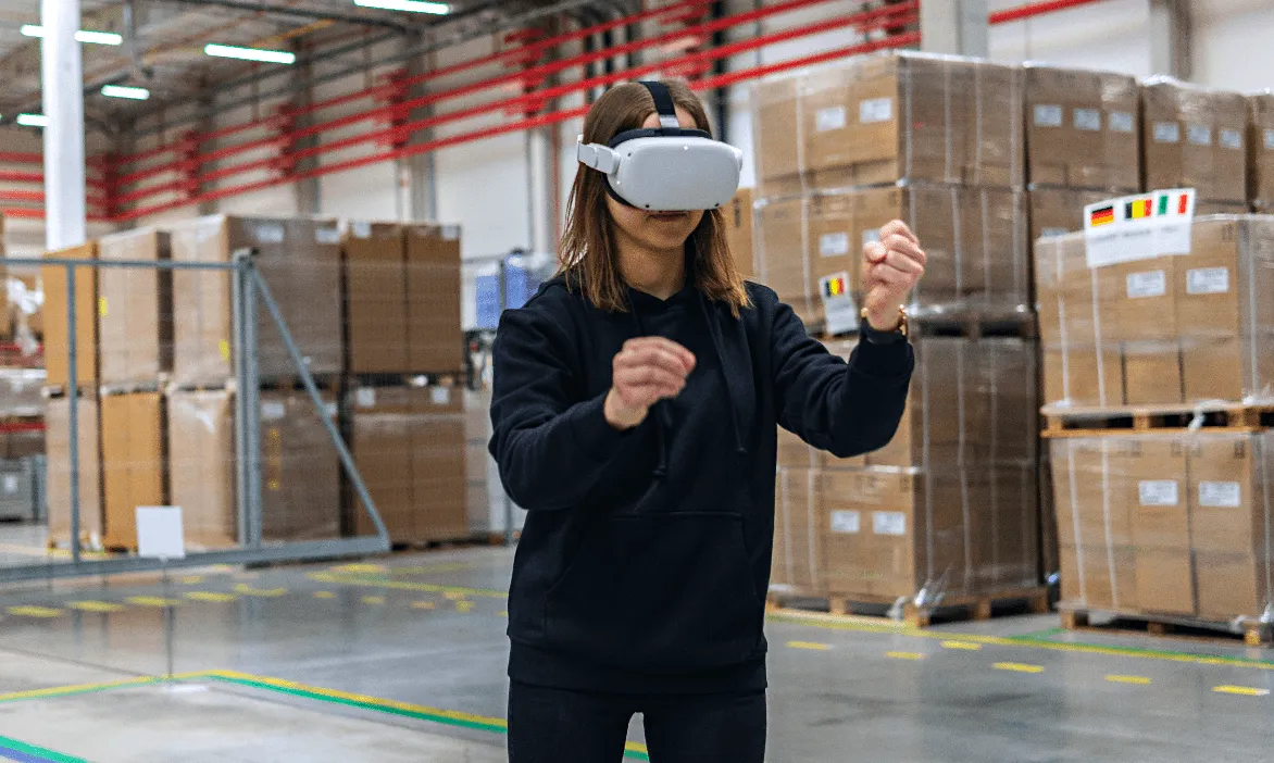Una mujer trabaja en una fábrica y completa una formación en PRL con gafas VR en un entorno virtual realista.