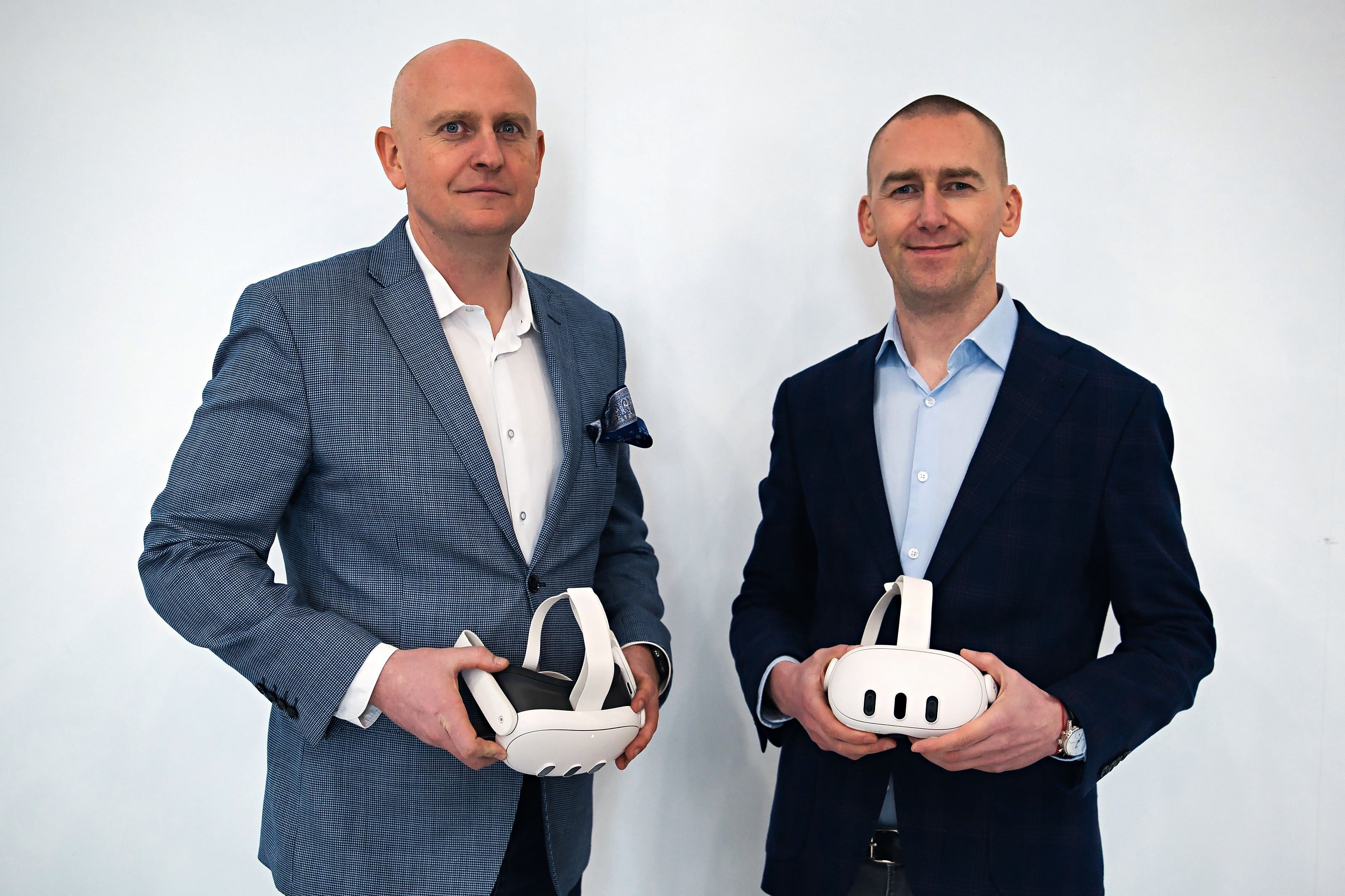 Two EHS VR founders in suits holding VR headsets