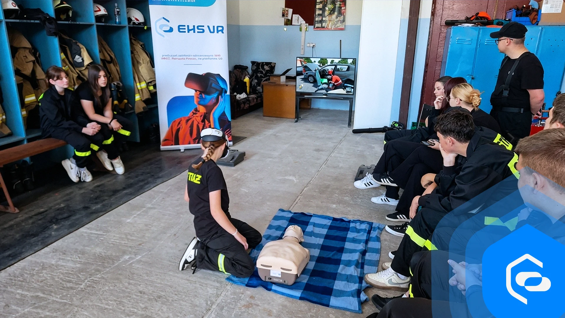 A girl in a VR headset practises resuscitation on a manikin while young volunteer firefighters watch in a fire station