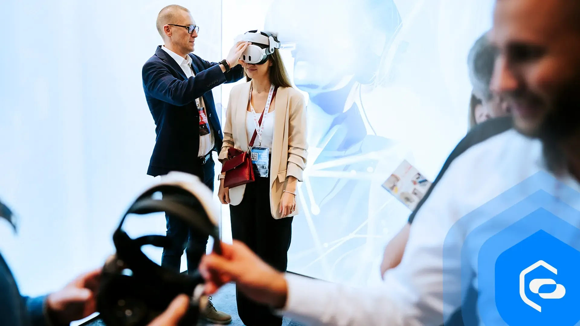 A man helps a woman put on a VR headset at the EHS VR stand during an industry forum