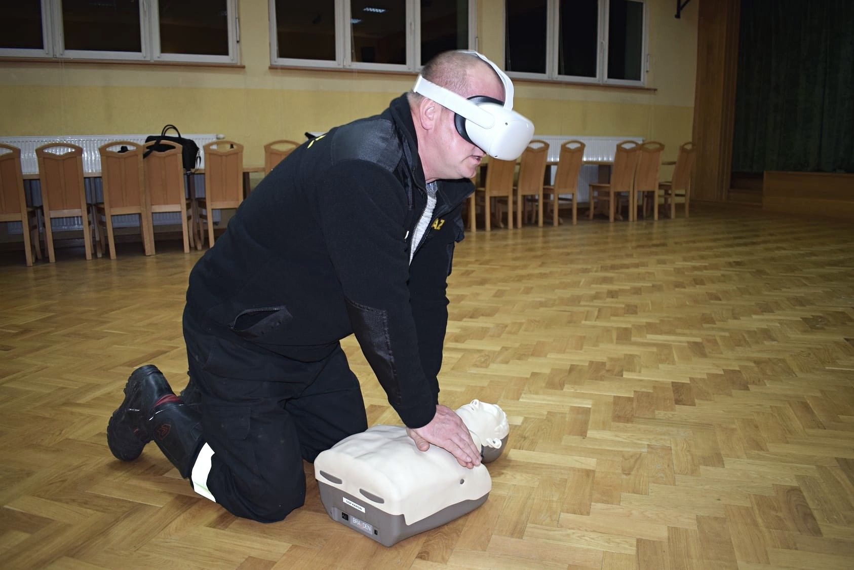 A firefighter in a VR headset practises CPR on a mannequin