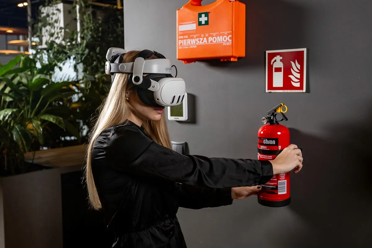 Participant in a VR headset holding a fire extinguisher during fire safety training