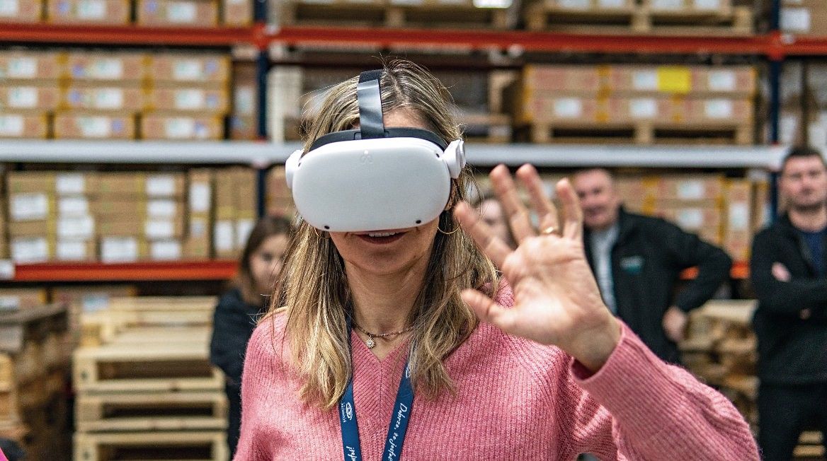 A woman training in a VR headset with hand tracking in a warehouse