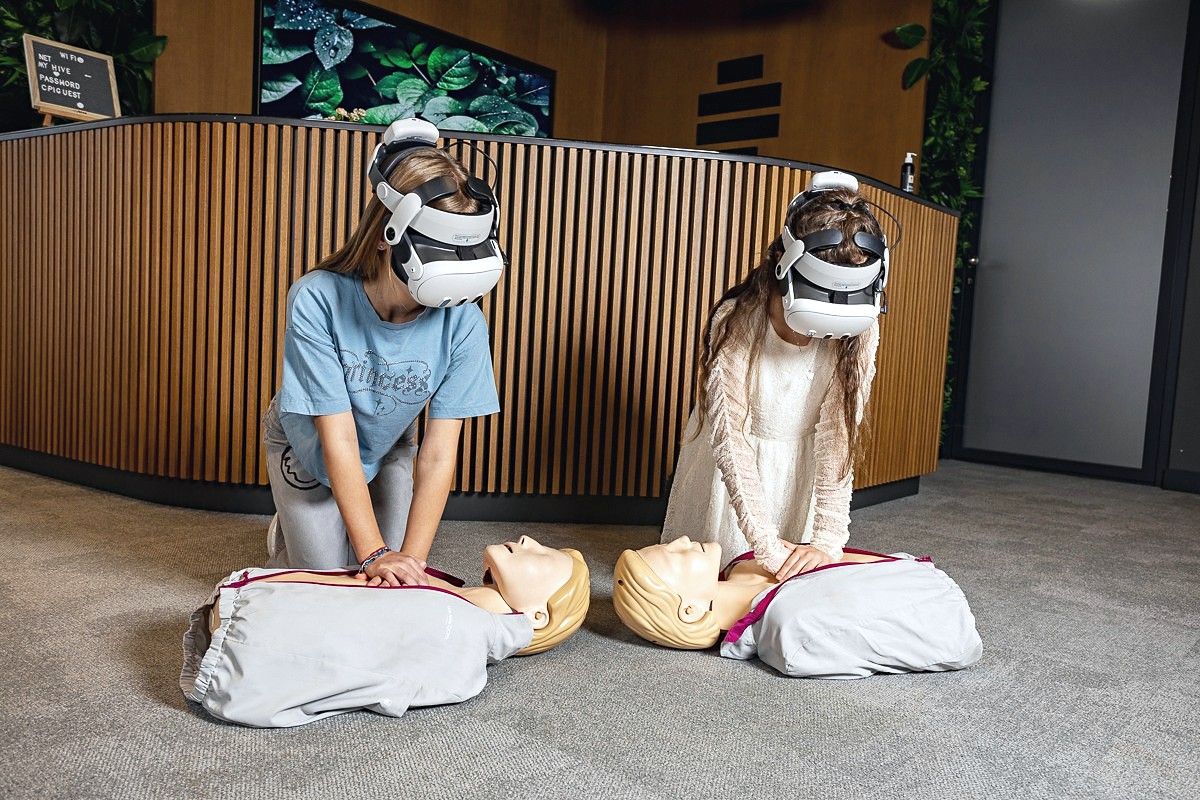 Children practicing CPR on manikins with VR headsets