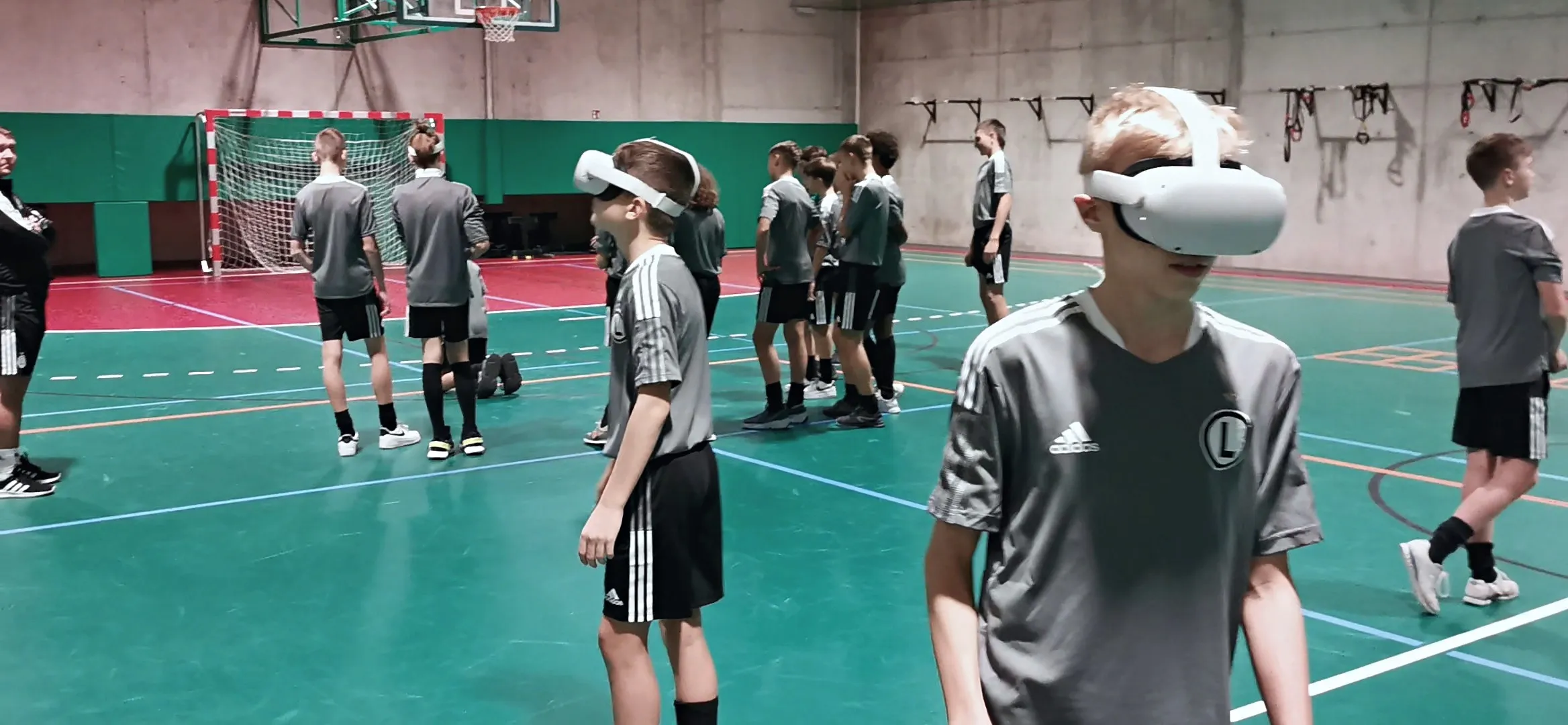 Young football players in VR headsets during first aid training in a sports hall